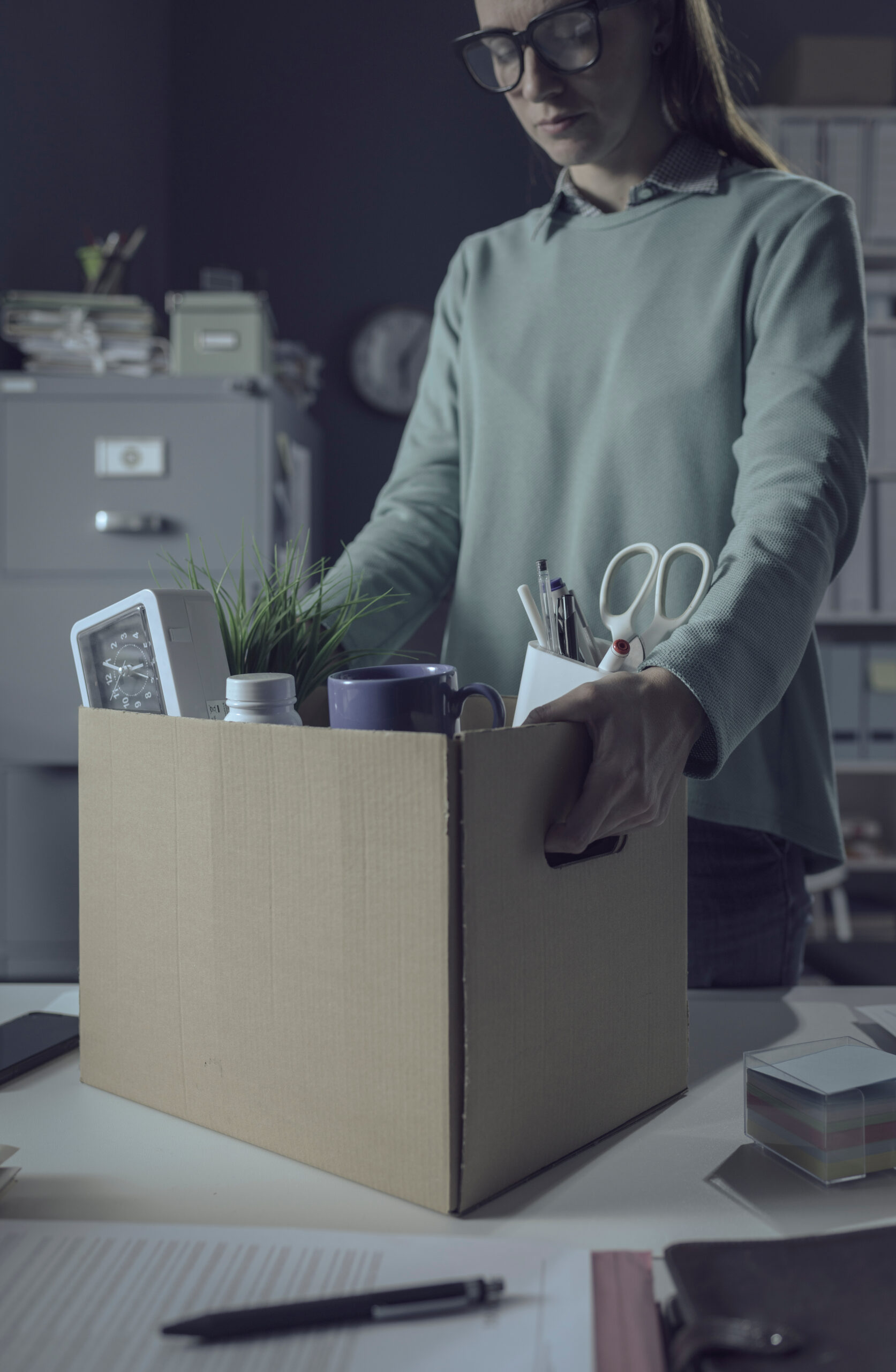 Sad woman packing her belongings in the office